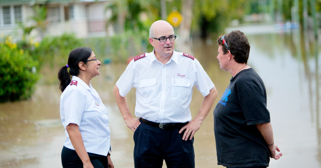 Officers talking to a woman affected by the Queensland flood