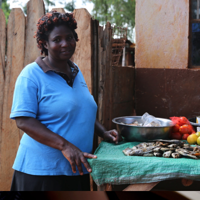 A Kenyan woman with local fish, fruits and vegetables